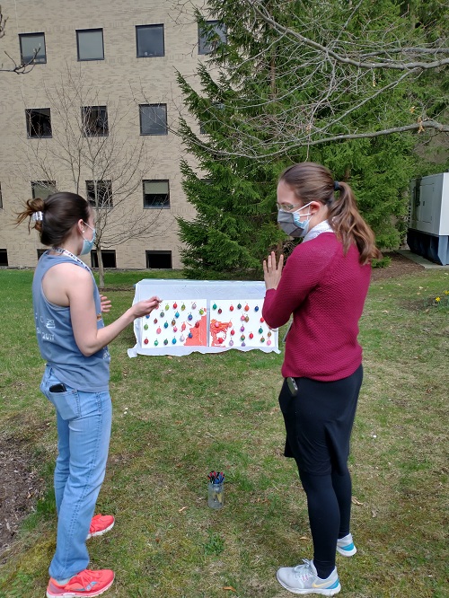 lab members getting ready to throw darts at balloons