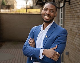 young man in a blue blazer smiling 