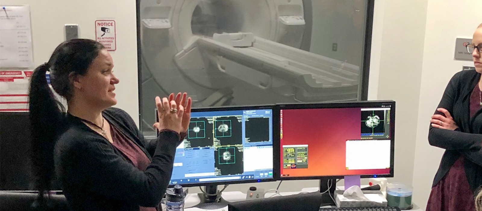 Employee speaking in front of MRI machine 