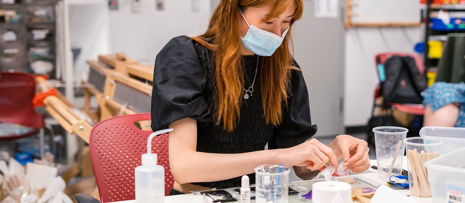 young woman with a mask on working in a lab
