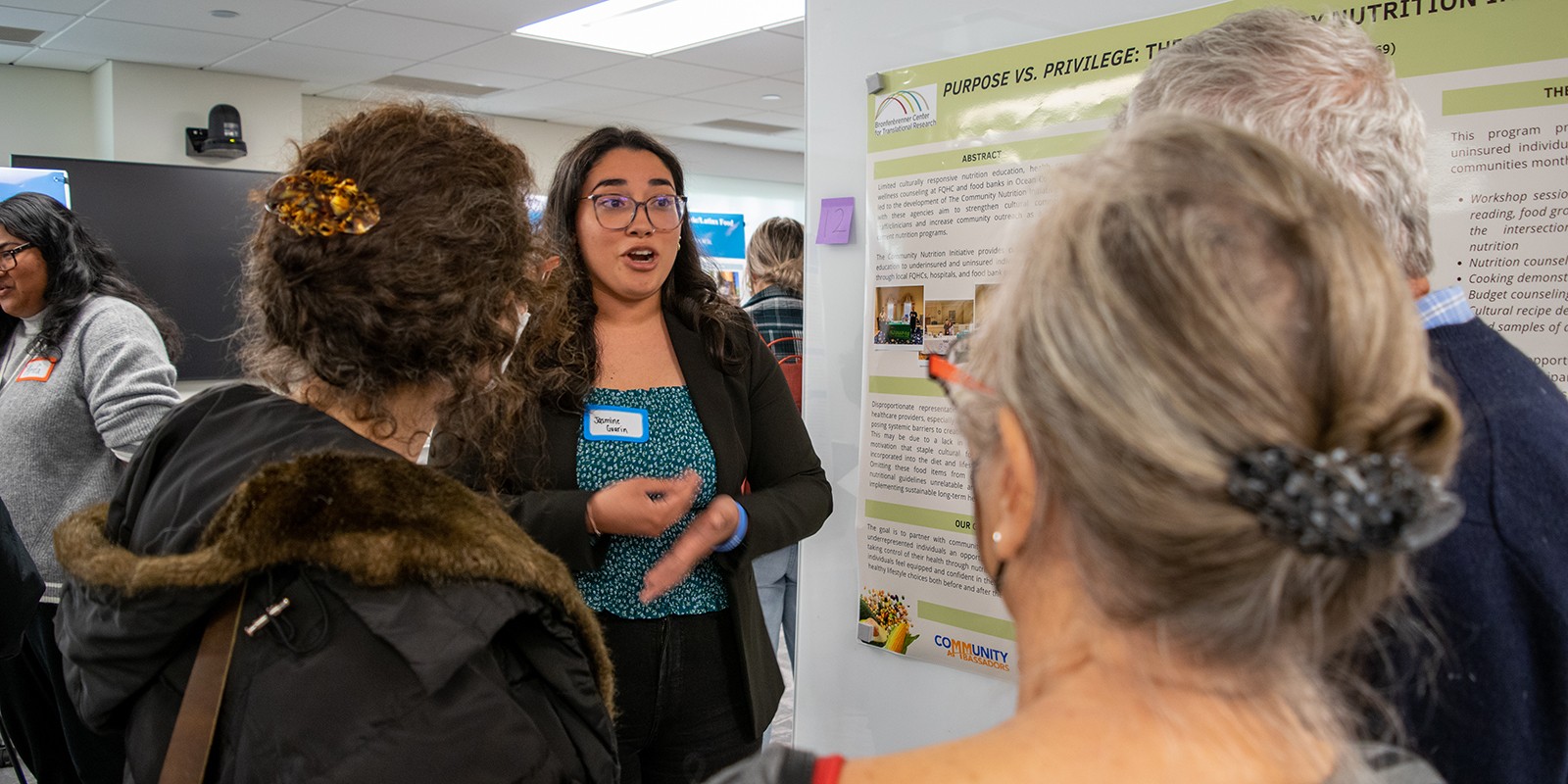 Jasmine Guarin ’24 speaks with attendees at an event.