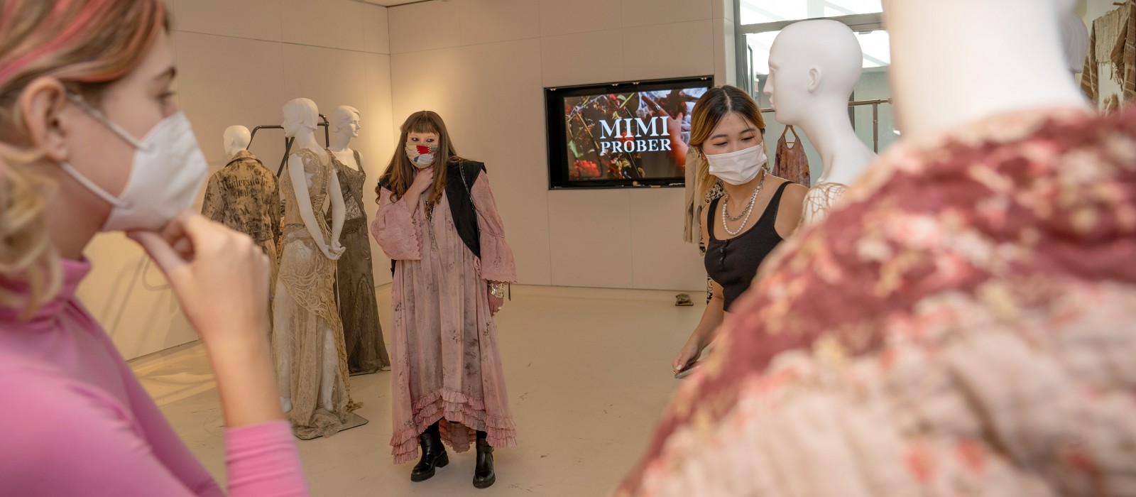 Mimi Prober with fashion design students looking at clothing