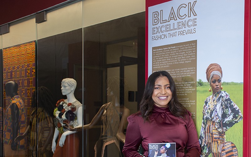Sian Brown in front of Black Excellence exhibit case
