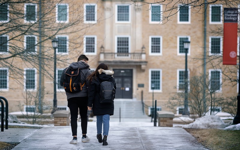 two students walking on a winter Cornell campus