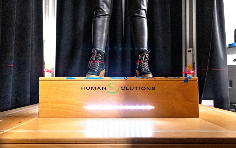 pair of legs standing on a wooden box that says "Human Solutions" on it