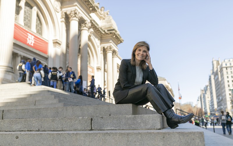 woman sitting on the steps of The Metropolitan Museum of Art in NYC