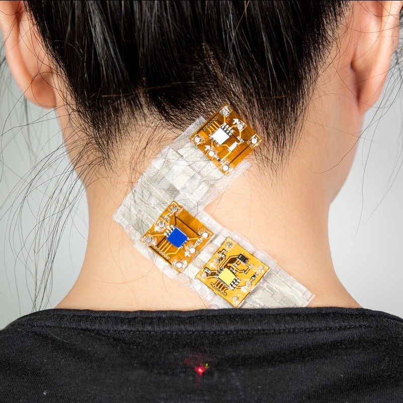 close up of the back of a person's head with sensors attached to their neck