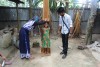 child being measured for height in village setting