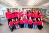 group of students in red shirts posing with a skeleton