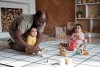 Father with two babies playing with toys on the floor
