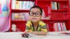 child with glasses at desk